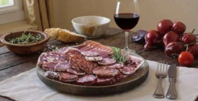 Tábua de chouriço fatiado com taça de vinho tinto Beira Interior.