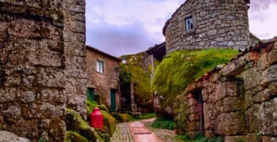 Ruela estreita de Monsanto com casas construídas entre blocos gigantes de granito.