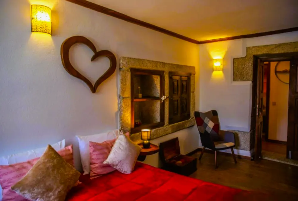 Cama com cabeceira de madeira (coração recortado) e janela de granito.