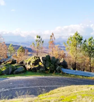 Estrada panorâmica serpenteando entre rochas de granito e musgo no Miradouro dos Quatro Ventos, um dos 7 miradouros da Beira Interior.