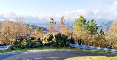 Estrada panorâmica serpenteando entre rochas de granito e musgo no Miradouro dos Quatro Ventos, um dos 7 miradouros da Beira Interior.