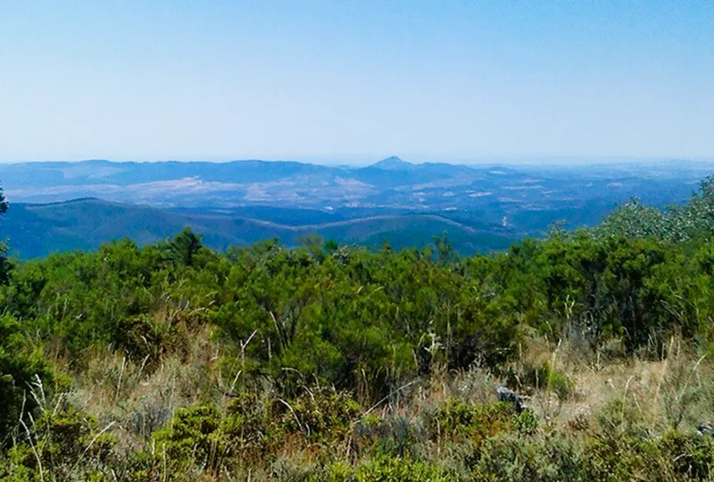 Horizonte infinito e montanhas onduladas avistadas do Miradouro Sete Concelhos na região de Penamancor.
