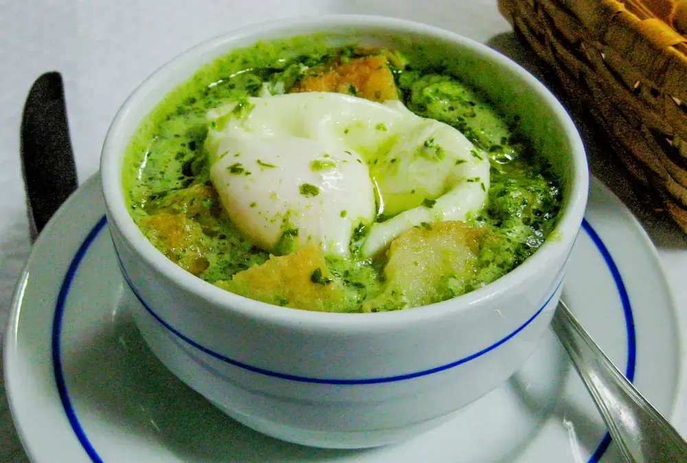 Açorda de poejos com ovo escalfado servida em mesa de tasca típica no Alentejo. Muito comum na Gastronomia das Estradas Secundárias.
