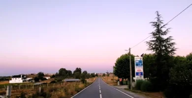 Estrada secundária reta e vazia durante o pôr do sol, representando o conceito de Slow Travel e tranquilidade.