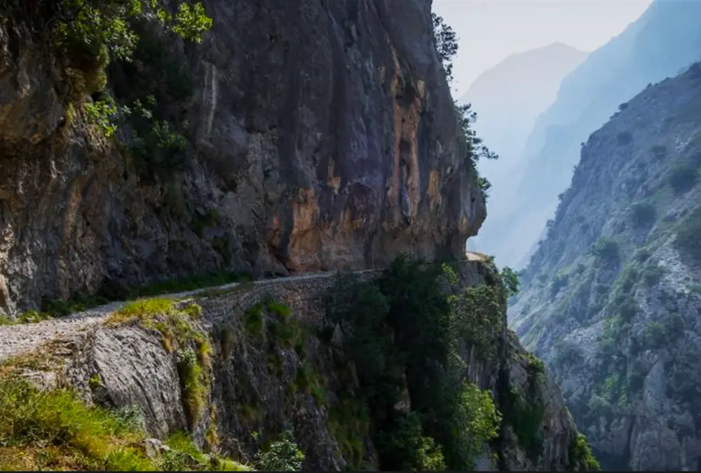 Trilho escavado na rocha na Garganta do Cares, Picos de Europa, um dos percursos mais icónicos das estradas secundárias espanholas.
