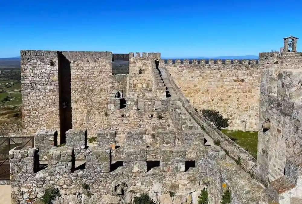 Vista aérea das muralhas e pátio de armas do Castelo de Trujillo, com as torres de vigia sobre a paisagem da Extremadura.