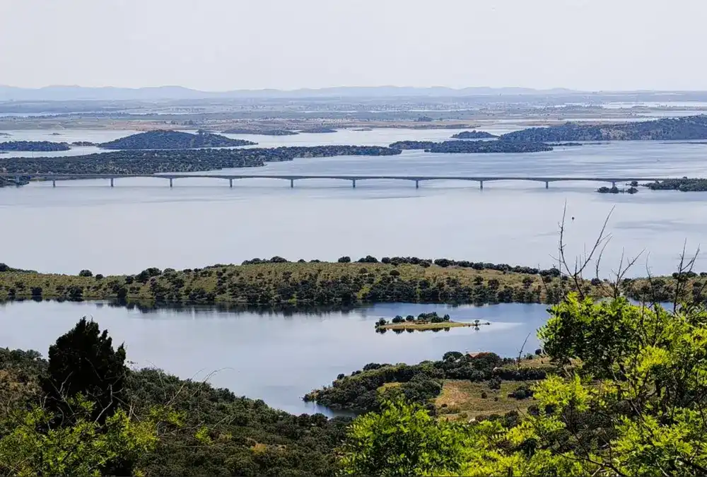 Vista panorâmica do grande lago do Alqueva com pontes e ilhas sob céu claro, perto de Monsaraz.