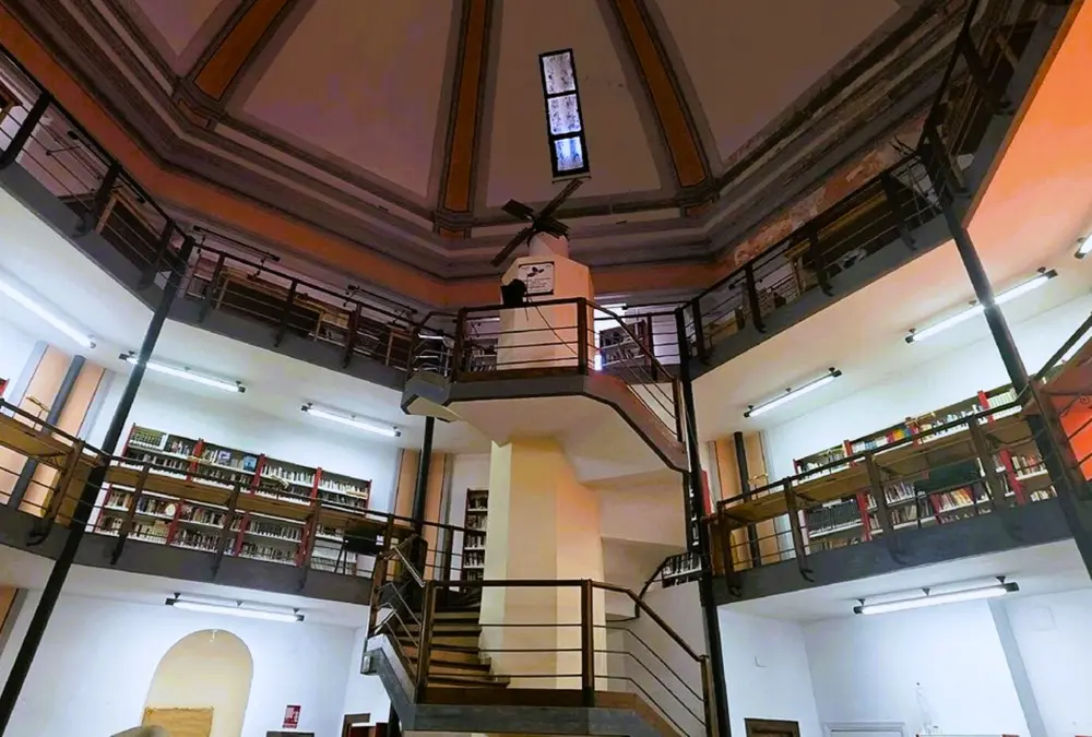 Interior da biblioteca de Tembleque com estrutura de madeira em forma de moinho.