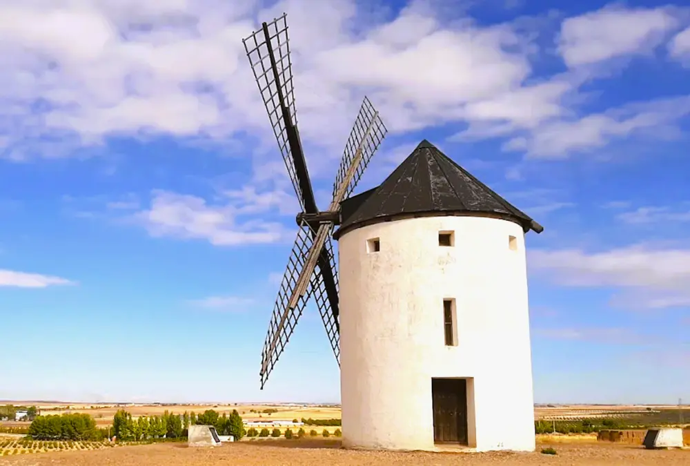 Moinho de vento tradicional branco sob céu azul na vila de Tembleque, Toledo.