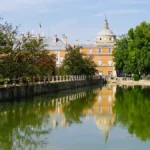 Vista do Palácio Real de Aranjuez refletido nas águas do rio a partir da ponte.