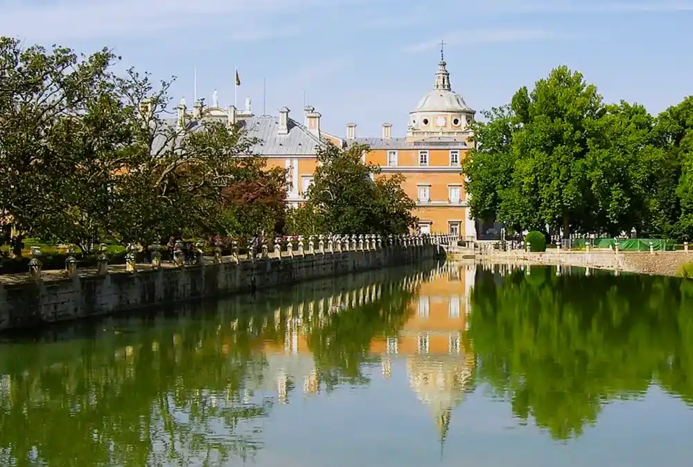 Vista do Palácio Real de Aranjuez refletido nas águas do rio a partir da ponte.