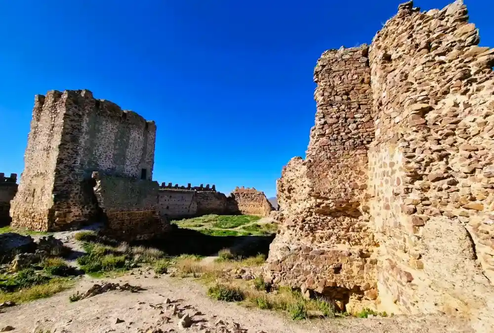 Ruínas do pátio interior e muralhas de pedra do Castelo de Almonacid de Toledo.