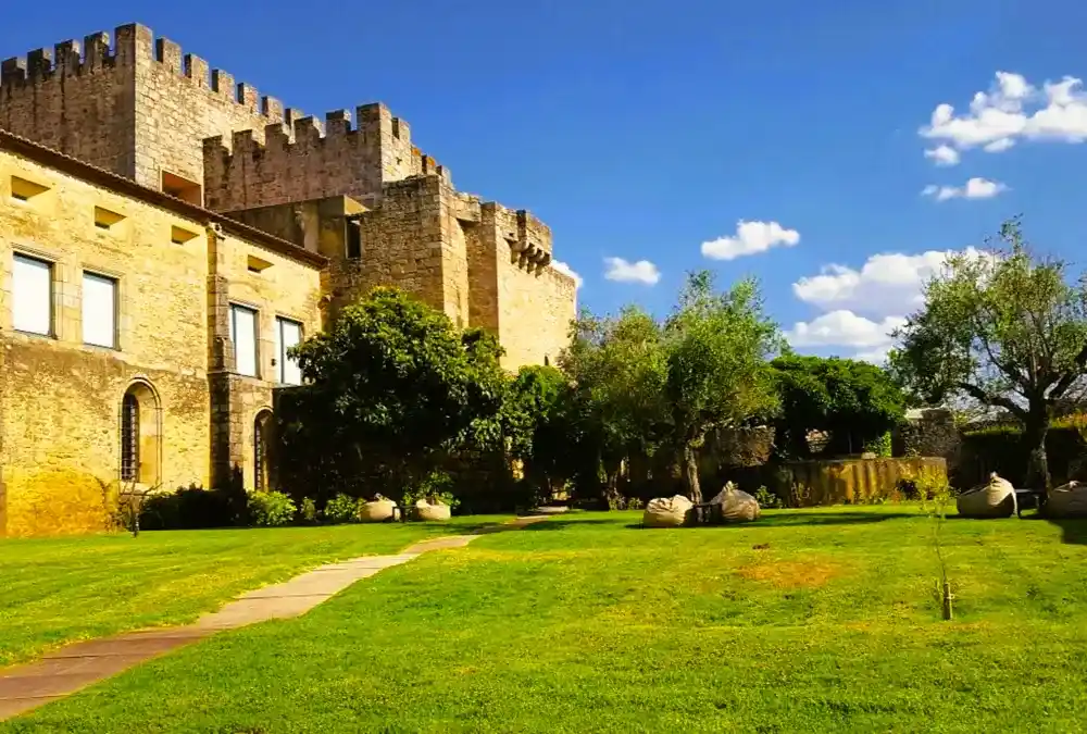 Vista lateral e jardins da Pousada Mosteiro Crato, destacando a arquitetura fortificada medieval.
