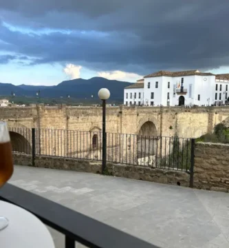Cafés com Vista nas Cidades Brancas da Andaluzia: mesa de esplanada com taça de cerveja em primeiro plano e a Puente Nuevo de Ronda ao fundo.