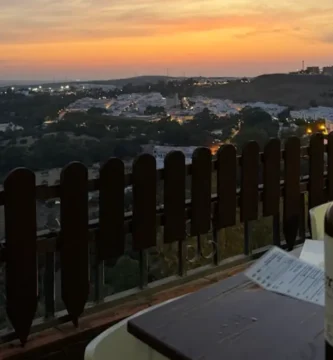 Mesa com vinho local ao pôr-do-sol com vista para Arcos de la Frontera, Andaluzia.