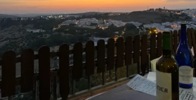Mesa com vinho local ao pôr-do-sol com vista para Arcos de la Frontera, Andaluzia.